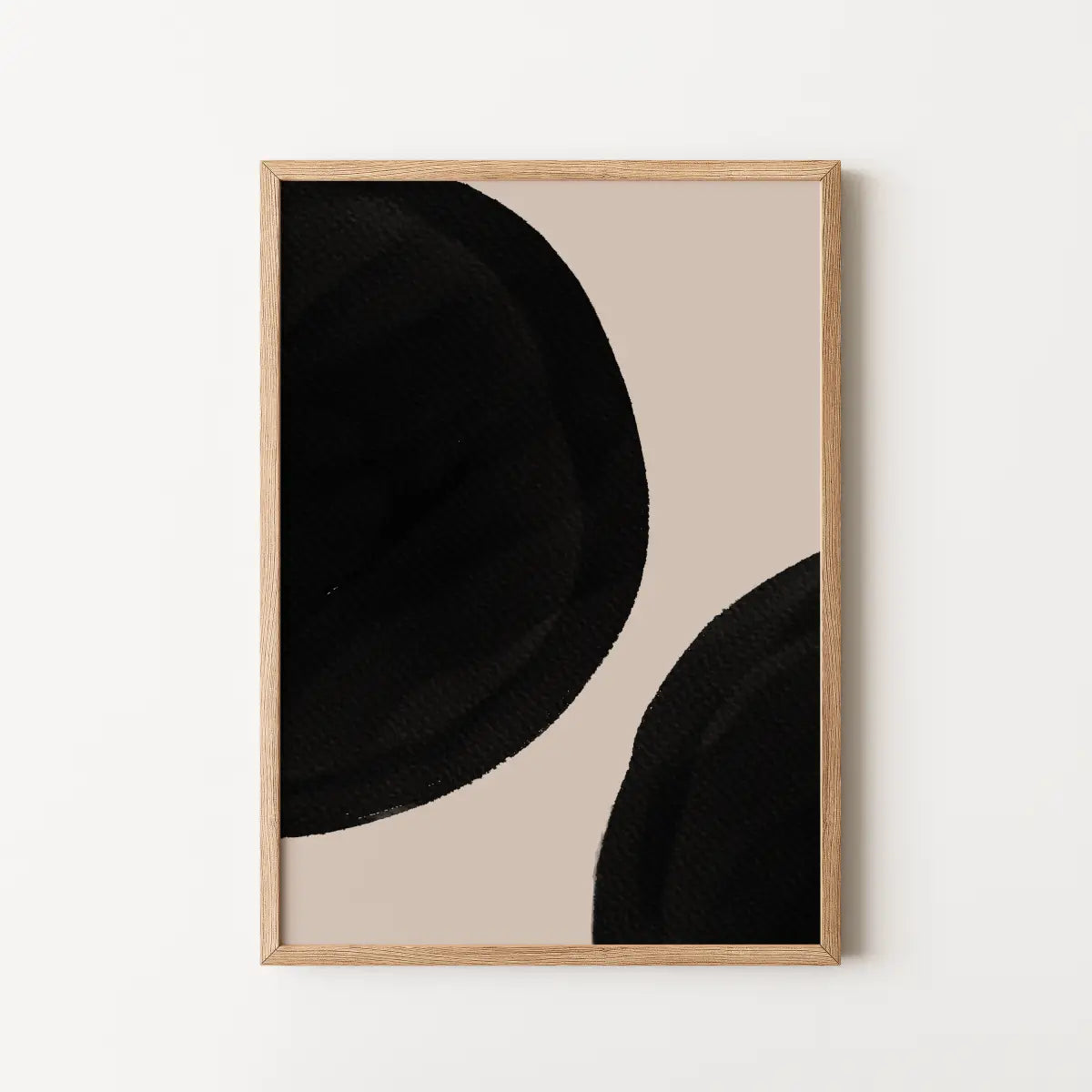 Framed abstract wall art featuring bold black organic shapes on a warm beige background.
