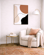 Modern living room with a beige armchair, abstract art, and gold side table.