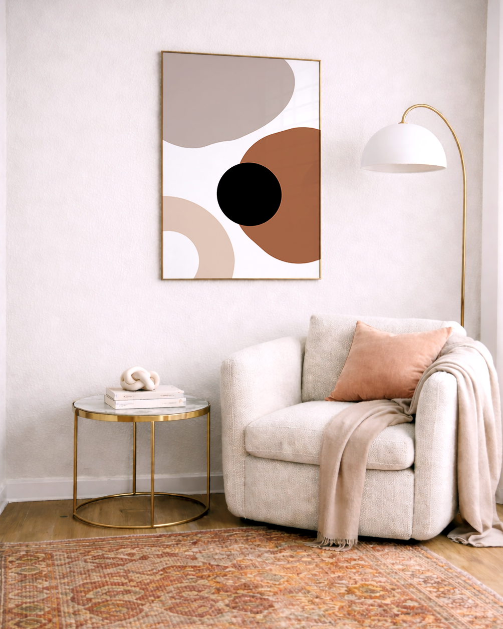Modern living room with a beige armchair, gold side table, and abstract burnt orange wall art.