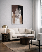 Modern living room with a beige sofa, abstract brown and neutral wall art, and decorative items.