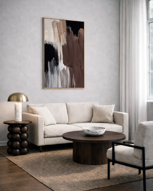 Modern living room with a beige sofa, abstract brown art, and wooden coffee table.