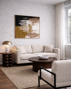 Modern living room with a beige sofa, abstract painting, and decorative items.