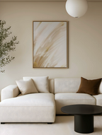 Modern living room with a white sofa, abstract gold and neutral art, and a black coffee table.