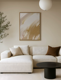 Modern living room with a white sofa, abstract gold canvas art, and a black coffee table.