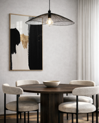 Dining room with a wooden table and chairs, abstract modern gold art on the wall, and modern pendant light.