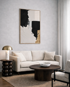 Modern living room with a beige sofa, wooden coffee table, and abstract gold art on the wall.