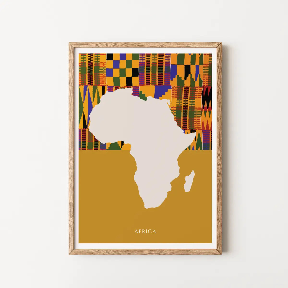 Framed art print featuring a minimalist silhouette of Africa with a colorful Kente-style pattern across the top and the word 'AFRICA' at the bottom, shown against a light neutral wall.