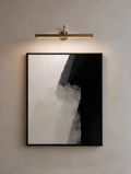 Modern wall light fixture above a framed abstract neutral calm wall art
